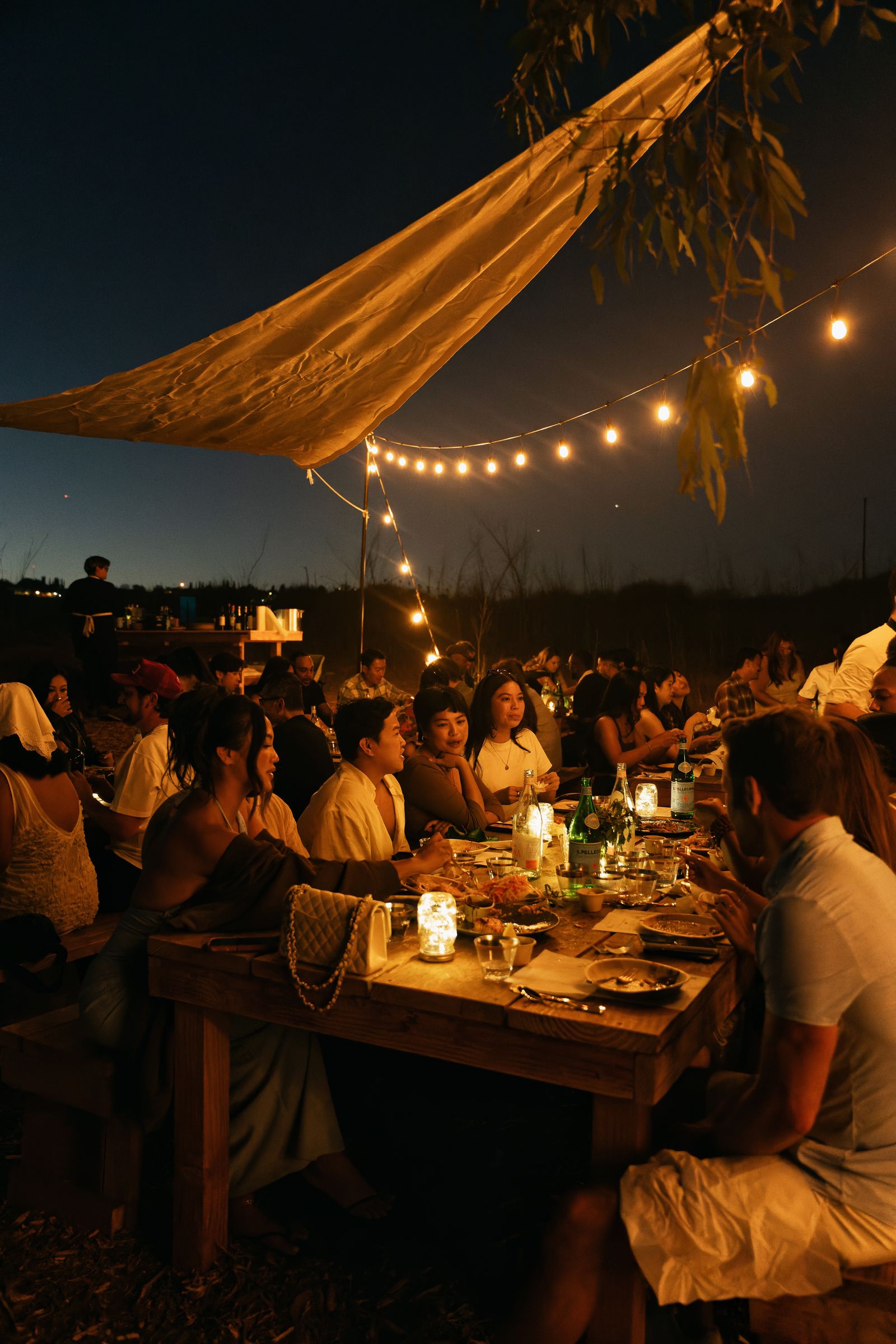 Guests, fire and the long table at the Rosalynn Summer Series dinner on 8 August 2026