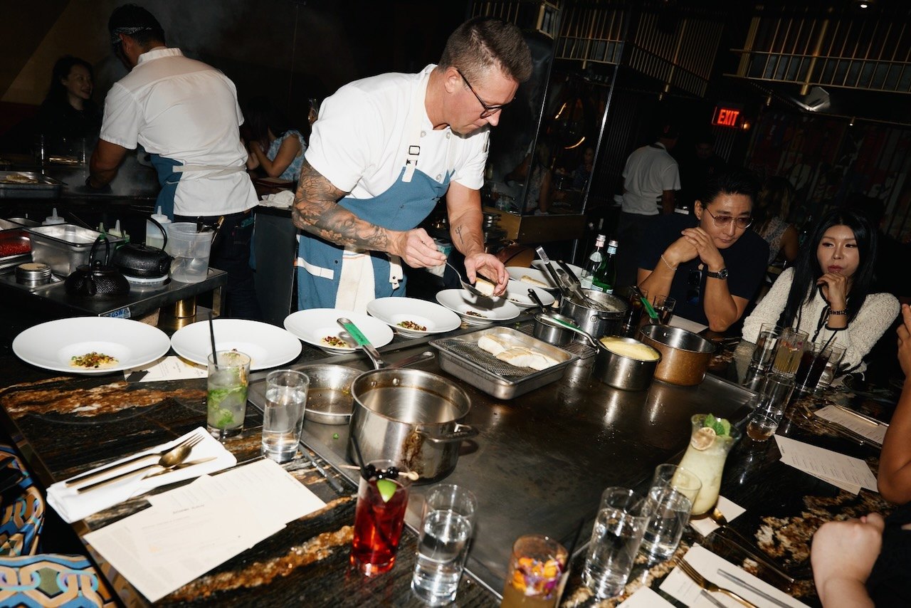 A competing chef finishing a plate in front of the room at HOT PLATE: Chef Showdown