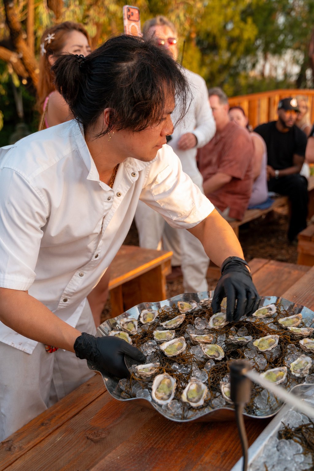 Chef presenting a tray of fresh-shucked oysters at a Rosalynn Seafood Soirée