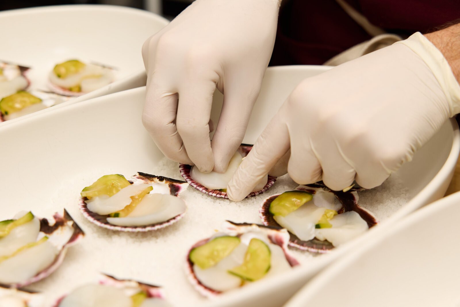 Plating scallop crudo on the line